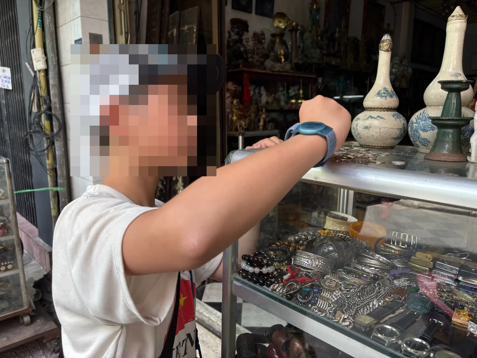 レ・コン・キエウ通りの骨董店で古銭を確認する子ども