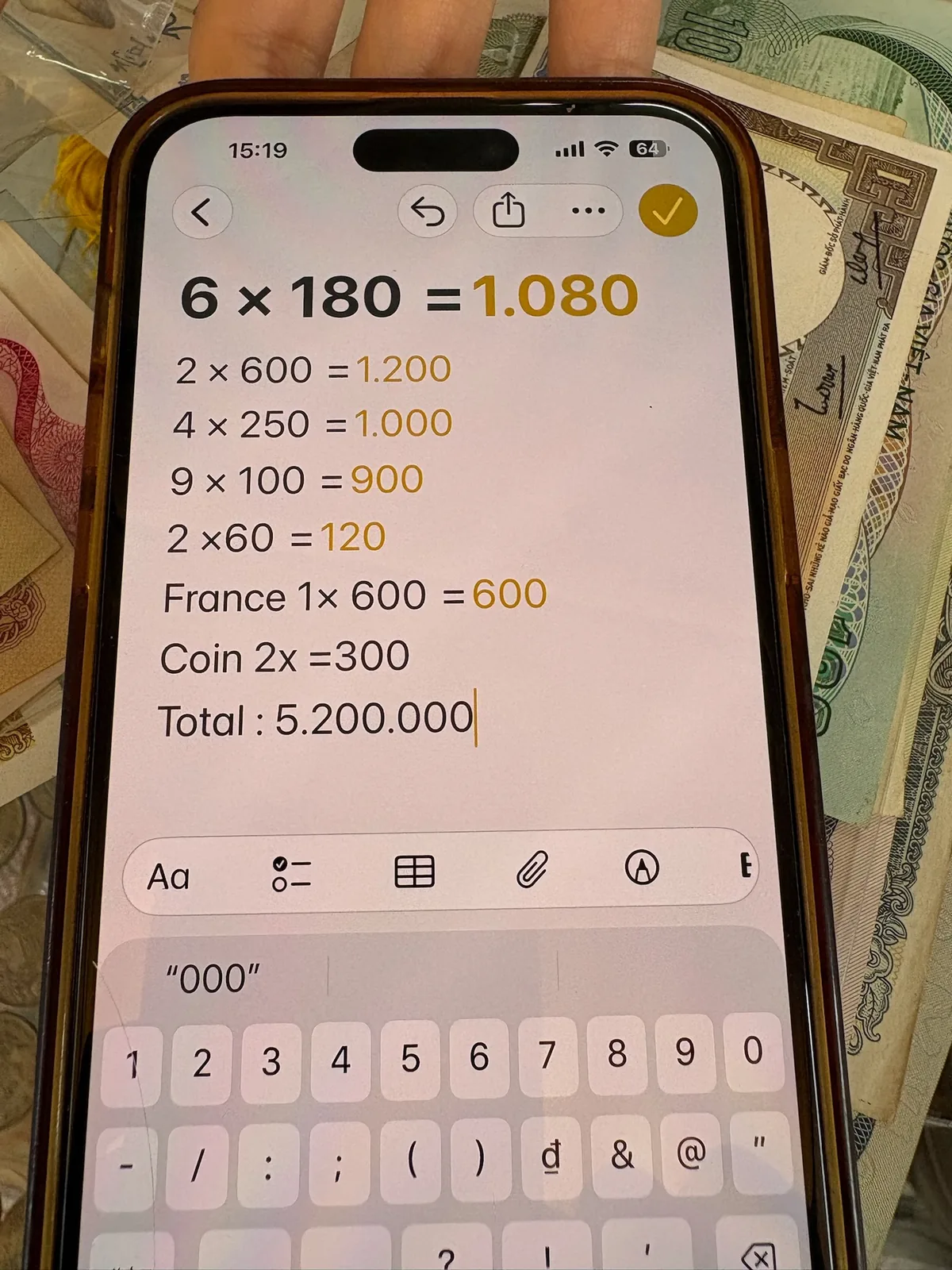 骨董店の店員がiPhone画面に記録した紙幣などの枚数と計算内容